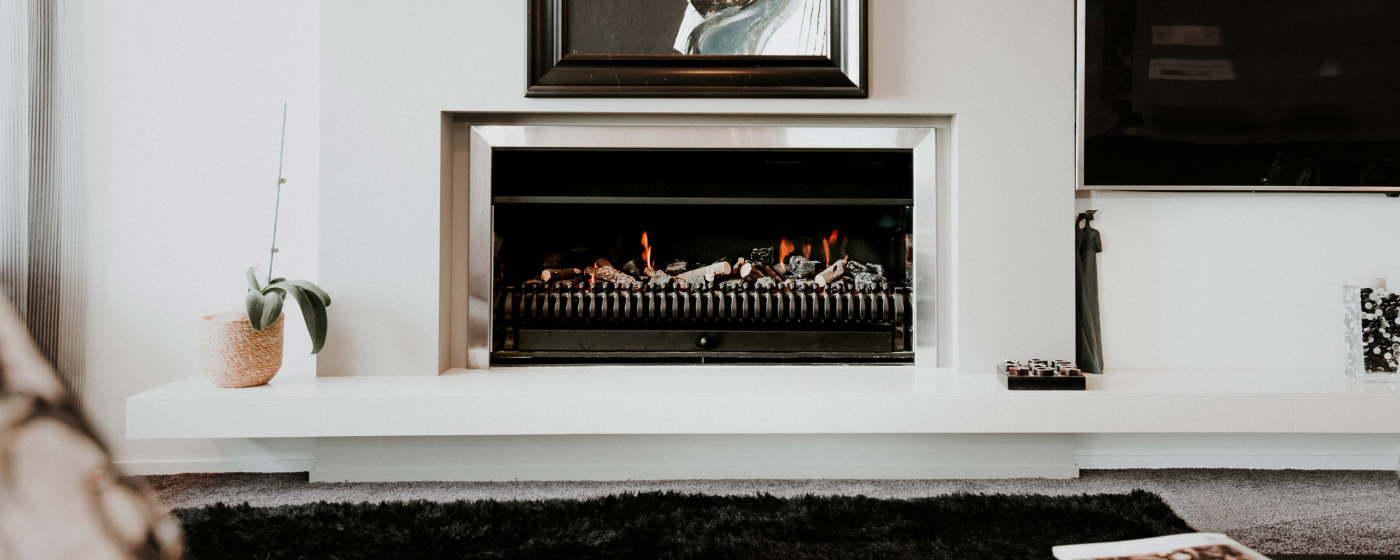 Decorative gas log fire in white room